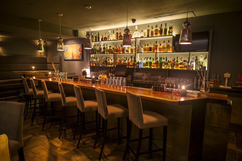 Carefully placed lighting and custom architectural millwork give this bar an intimate feel